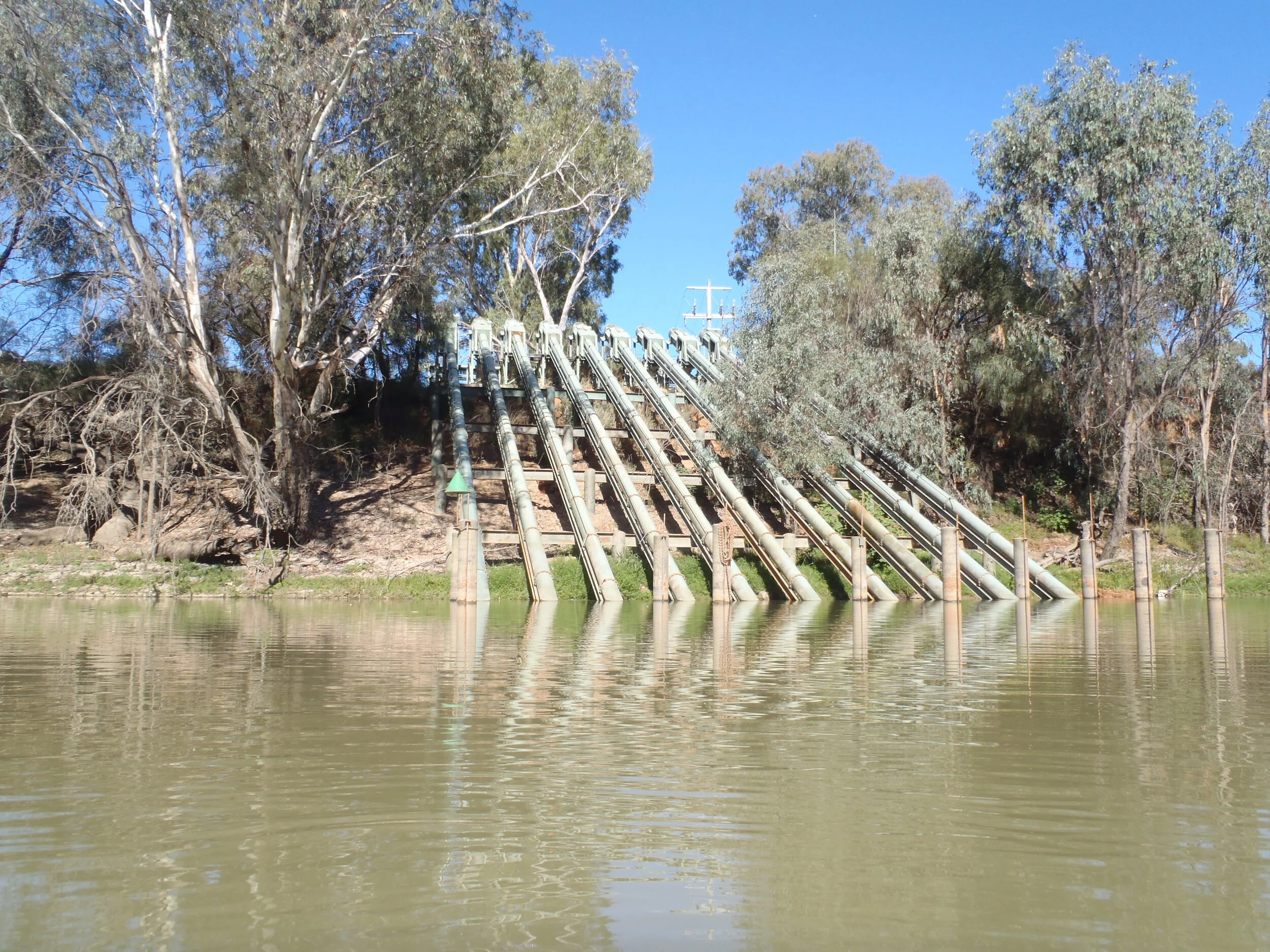 Ten pumps lifting from a river